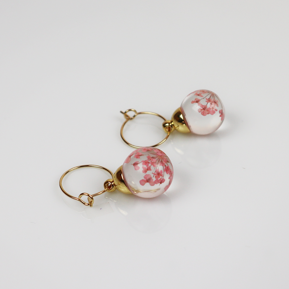 Pair of gold earrings with light pink dill