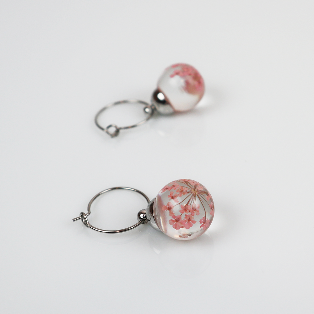 Paar zilveren oorbellen met dille licht roze