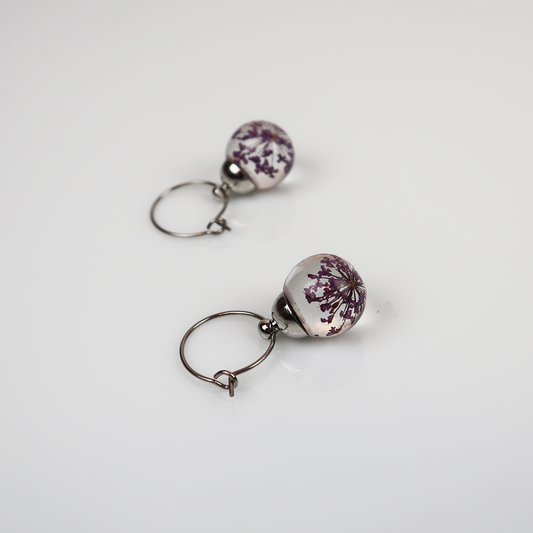 Paar zilveren oorbellen met dille paars
