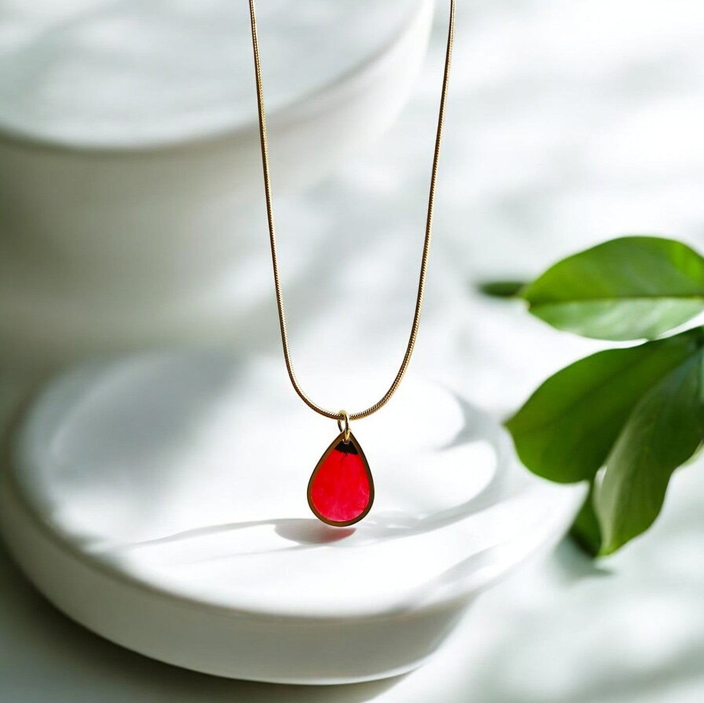 Drupt gouden ketting met minimalistische druppelvormige hanger waarin een echte rode klaproos is verwerkt.