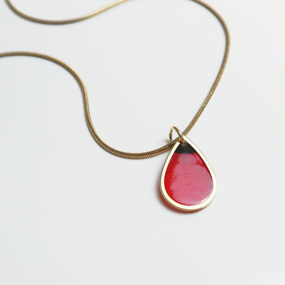 Drupt gouden ketting met druppelvormige hanger waarin een echte rode klaproos is verwerkt.