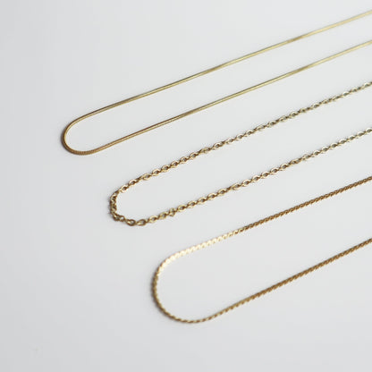 Drie verschillende gouden kettingen van Drupt voor de Koester hanger, gepresenteerd op een witte achtergrond.