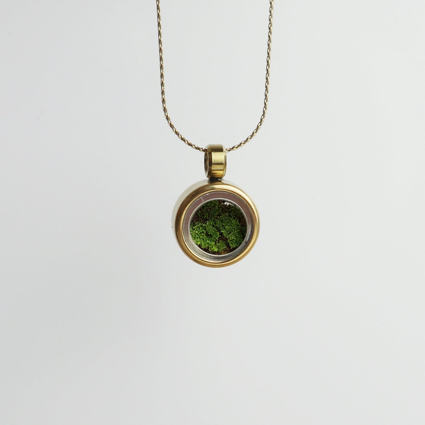 Drupt Koester hanger in goud met groene mosvulling aan een fijne ketting voor dierbare herinneringen.