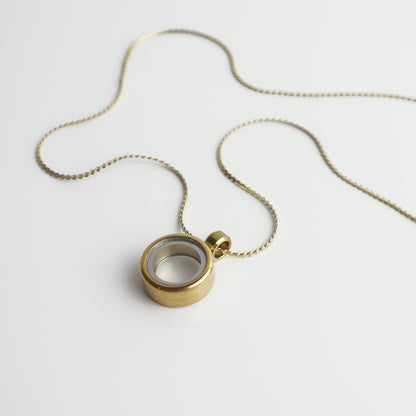 Drupt Koester goudkleurige ronde hanger aan een fijne ketting voor het bewaren van persoonlijke herinneringen.