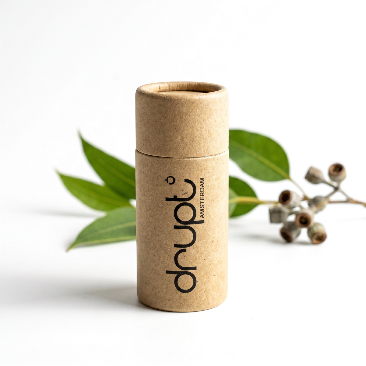 Drupt cadeauverpakking van bruin karton voor een Koester hanger, gepresenteerd met een takje eucalyptus.