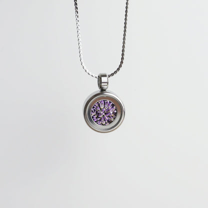 Drupt Koester zilveren hanger met paarse lavendelbloemetjes aan een fijne ketting tegen een witte achtergrond