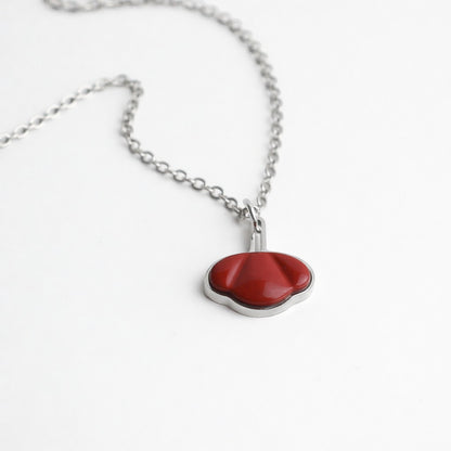 Drupt ketting met een rode jaspis hanger in de vorm van een klaproos, gezet in zilver op een witte achtergrond.