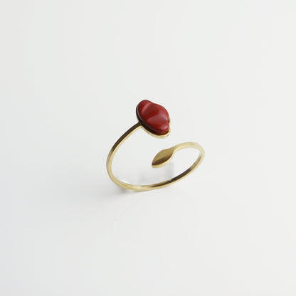 Drupt verstelbare ring met rode jaspis edelsteen in de vorm van een klaproos, gezet in goudkleurig metaal.