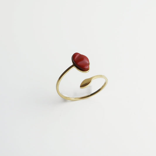 Drupt verstelbare ring met rode jaspis edelsteen in de vorm van een klaproos, gezet in goudkleurig metaal.