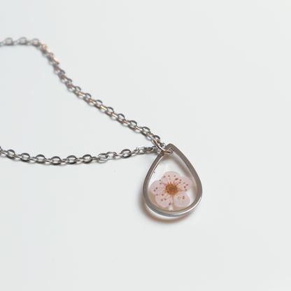 Drupt ketting met zilveren druppelvormige hanger en een echte roze pruimenbloesem in hars.