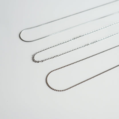 Drie verschillende zilverkleurige kettingen van Drupt voor de Koester hanger op een witte achtergrond.
